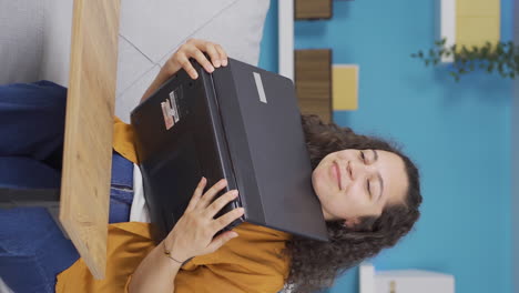 Vertical-video-of-Young-woman-joyfully-embracing-laptop.